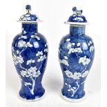 A pair of c1900 Chinese porcelain prunus baluster lidded vases, the lids with Dog of Fo surmounts,