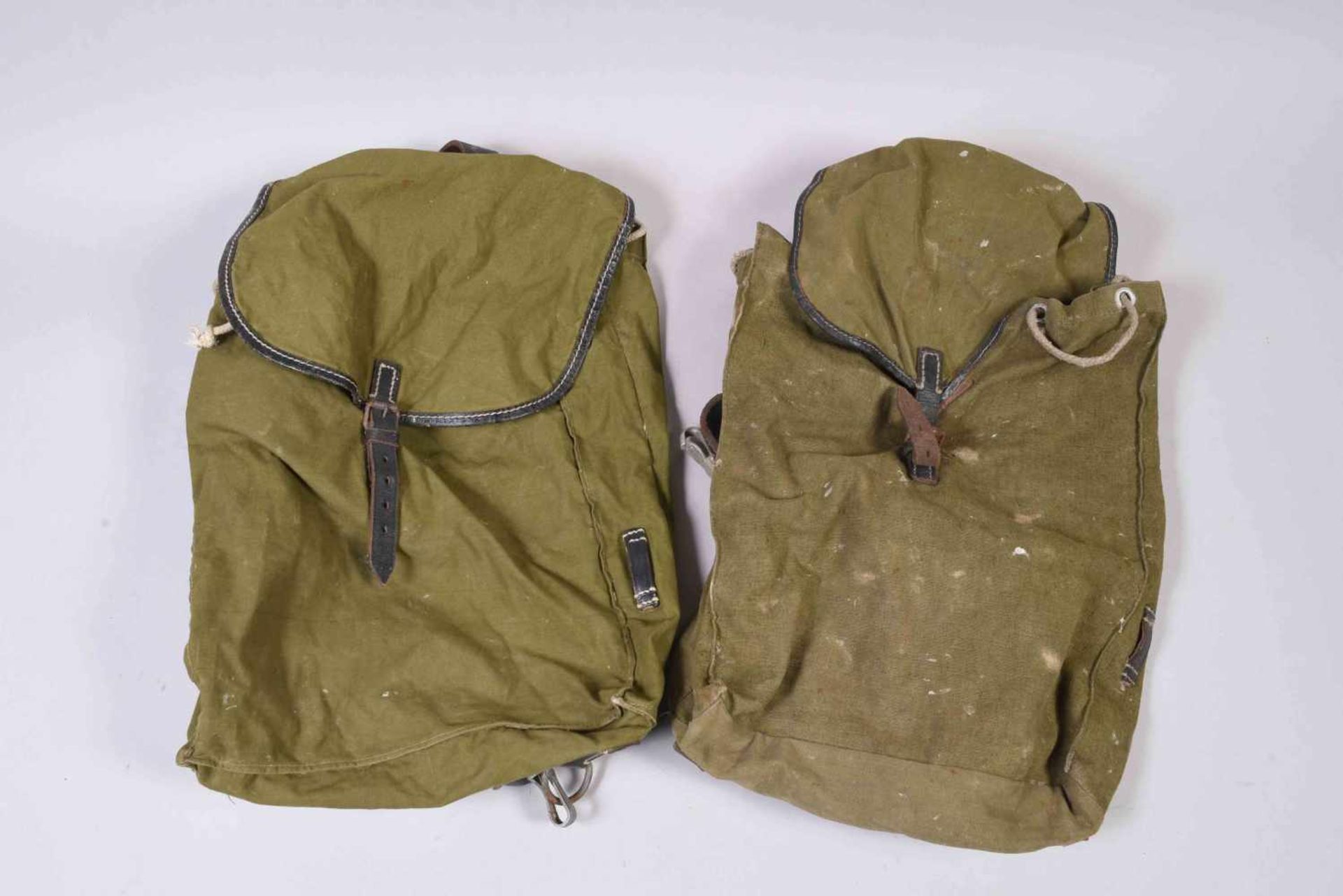 All- 2 petits sacs à dos WH en toile kaki à bretelles en cuir. Les deux datés 1940. Etat d’usage,