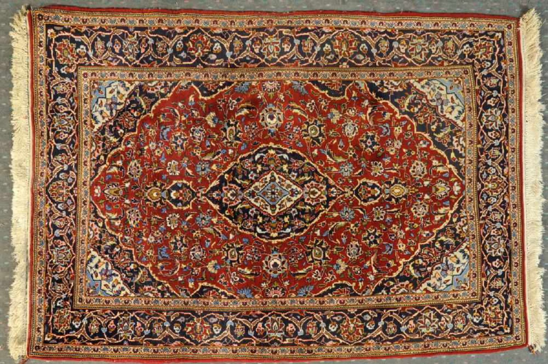 Keschan, Persien, 112 x 173 cmWolle, rotgrundig, mehrfarb. Mittelstück, umgeben von floralen