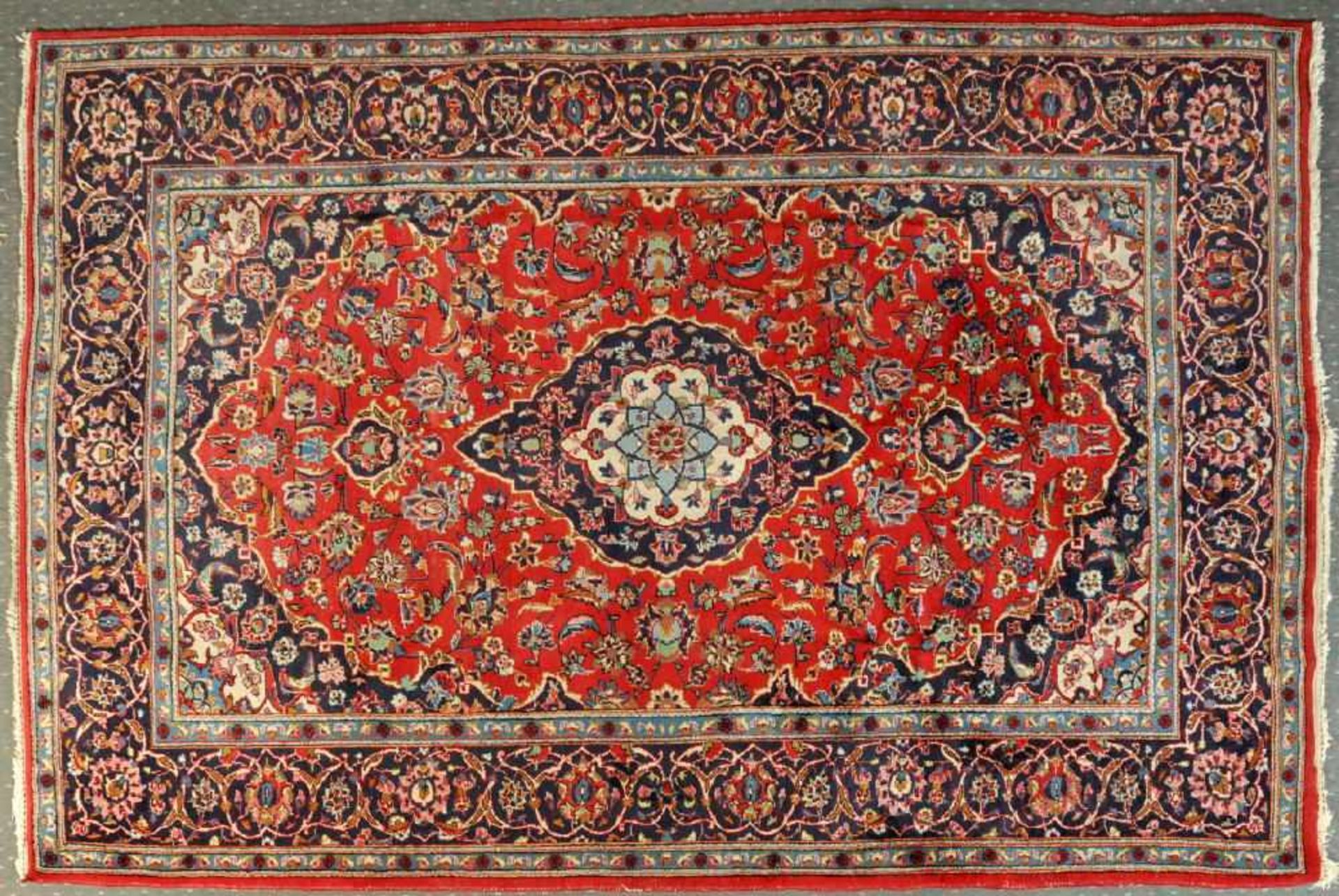 Keschan, Persien, 198 x 310 cmWolle, rotgrundig, mehrfarb. Mittelstück, umgeben von floralen