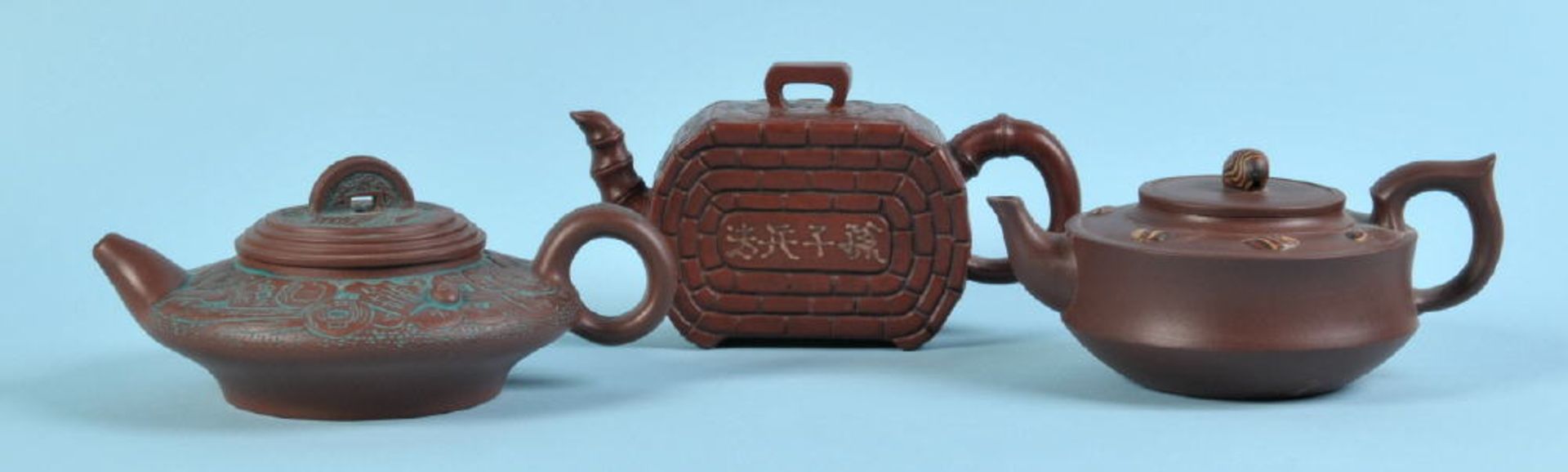 Teekännchen, 3 Stückbrauner Yixing-Ton, versch. Formen u. strukturierte Dekors, H= 7-9 cm, China
