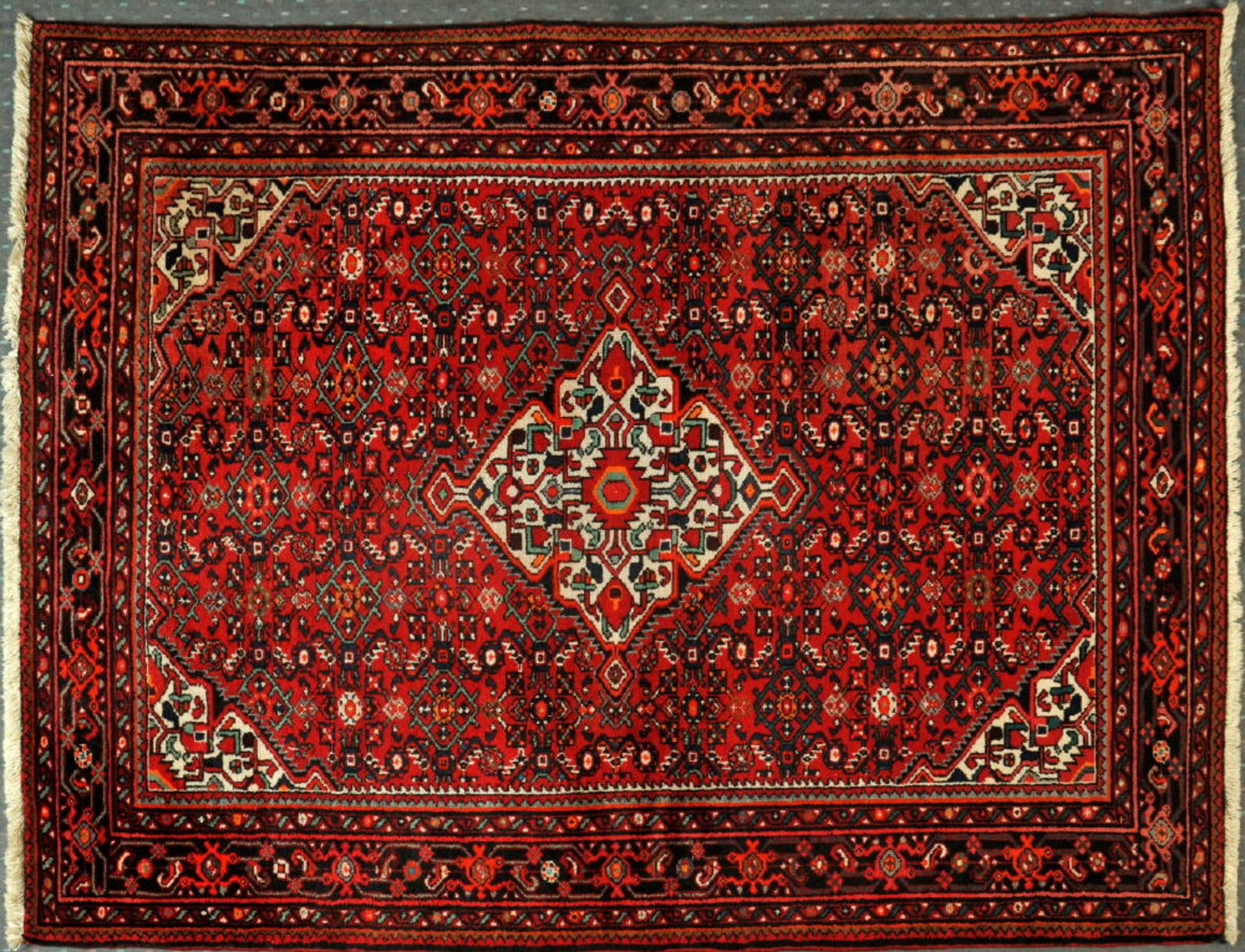 Ingelas, Persien, 162 x 223 cmälter, Wolle, rotgrundig, mehrfarb. Mittelstück, umgeben von stilis.