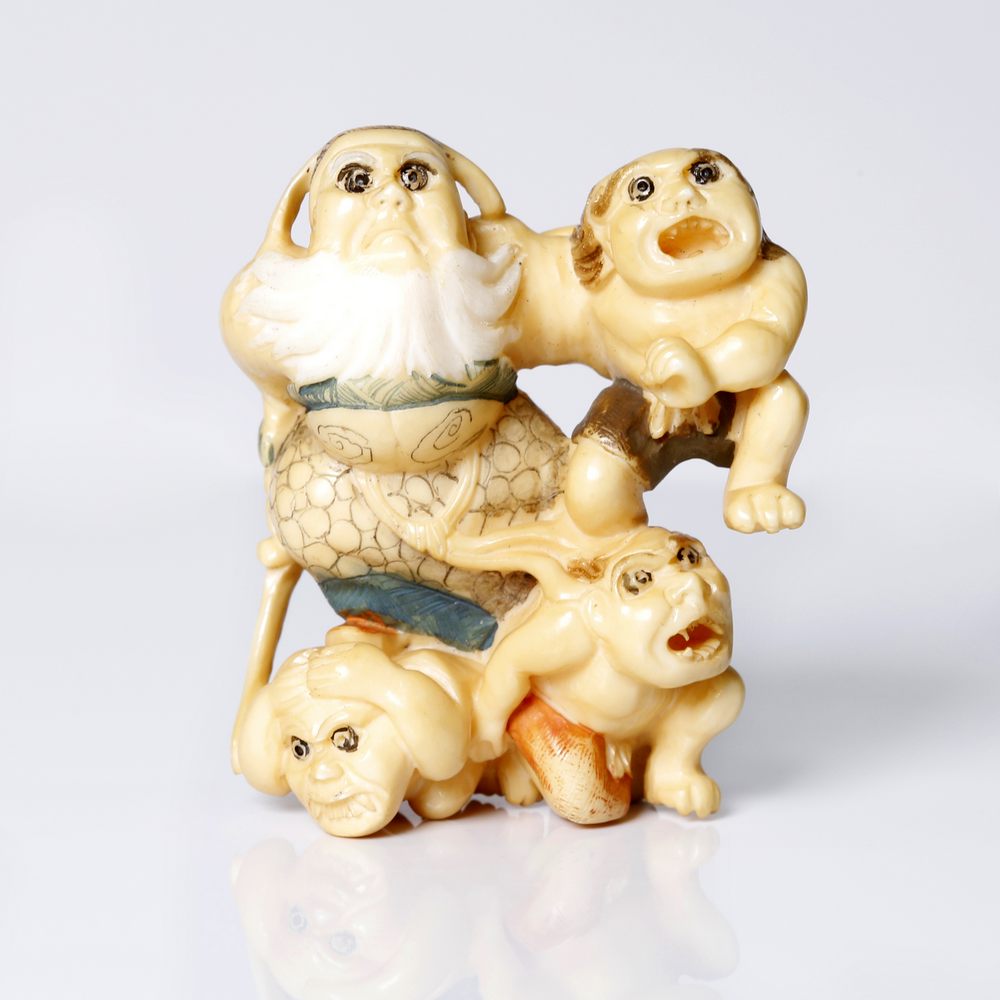 an antique, Japanese bone polychrome multi-figure netsuke.