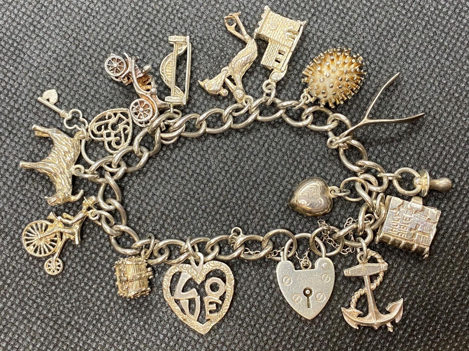 Vintage silver charm bracelet with lock and chain and 14 charms 49g