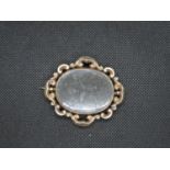 Mourning brooch with yellow metal untested - centre spins - hair plaited back - glass broken