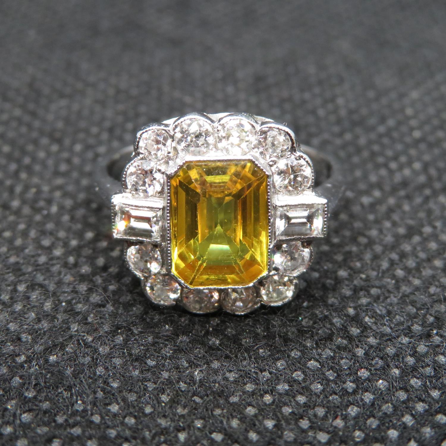 Art Deco platinum ring set with emerald cut yellow sapphire over 2cts surrounded by 14 round and