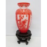 Red and white glass vase on stand