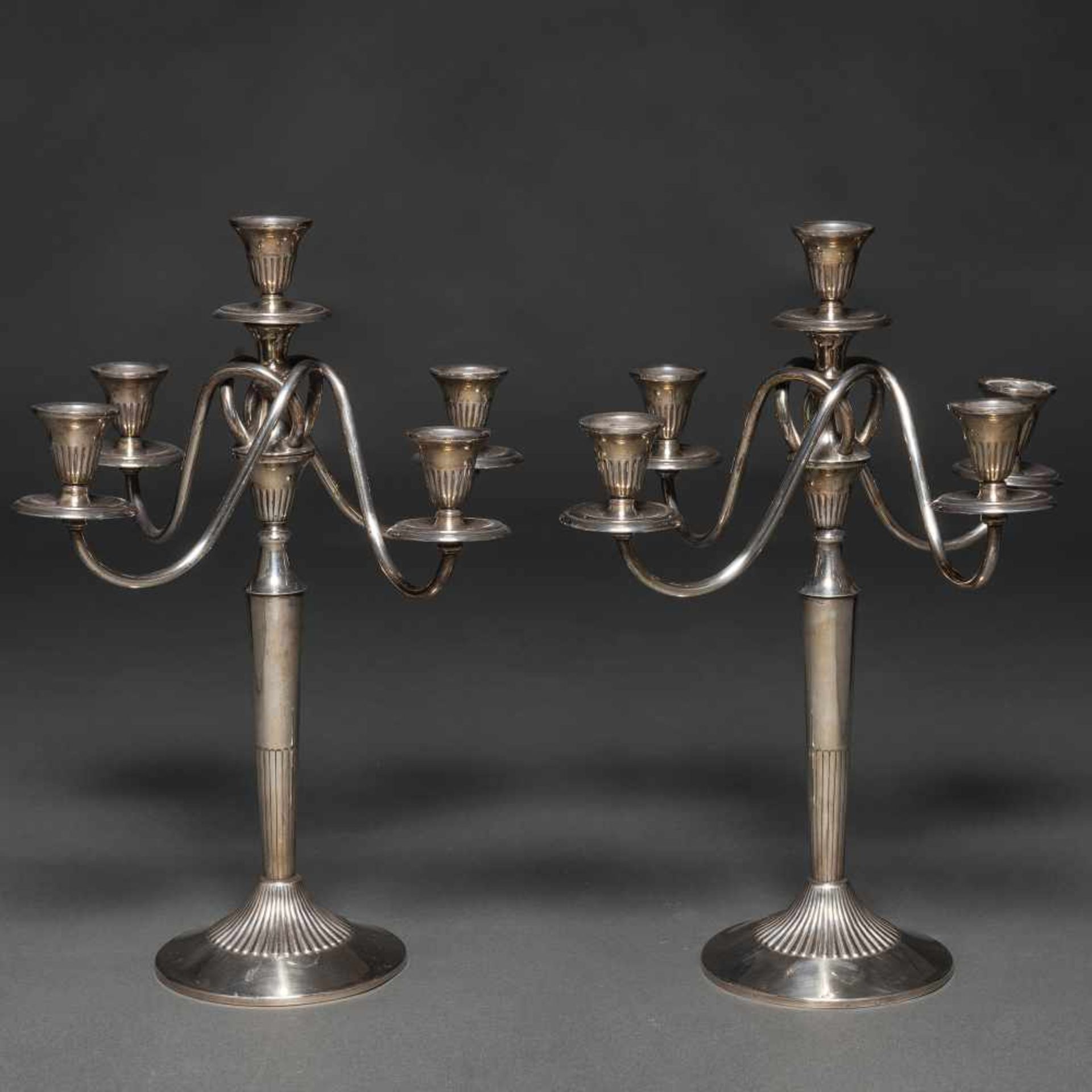 Elegante pareja de candelabros de cinco luces entrelazados en plata española punzonada. Ley, 925,