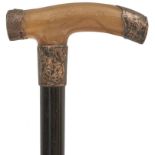 AN EDWARDIAN WALKING CANE, the rhinoceros horn handle with foliage engraved silver mounts hallmarked