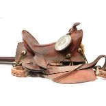 A WESTERN SADDLE, of characteristic leather form and with tooled decoration, probably 20th