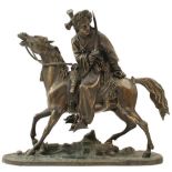 A BRONZE OF A MOUNTED BEDOUIN, with sword drawn, riding over cannon, 30cm high over all.