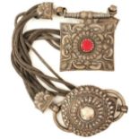 A TIBETAN WHITE METAL AND CORAL LARGE PENDANT, decorated with flowerheads, scrolls and stylized