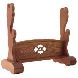 A JAPANESE OAK SWORD STAND, the central panel pierced with a stylized flowerhead.