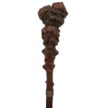 A 19TH CENTURY BLACK FOREST WALKING STICK, the pommel carved in the shape of a crouching man, on