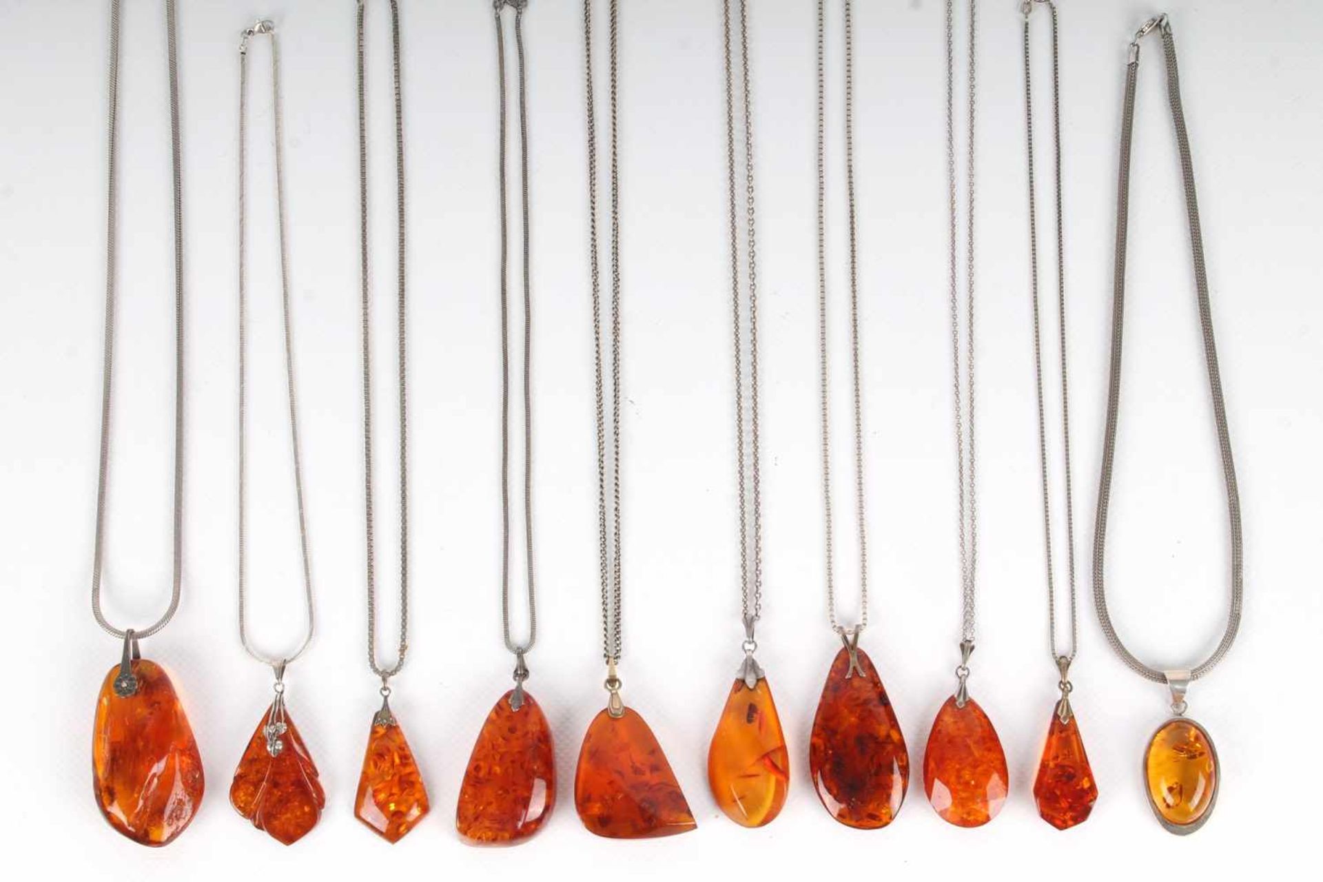 10 Bernsteinanhänger mit Silberketten, 10 amber pendants with silver chains,