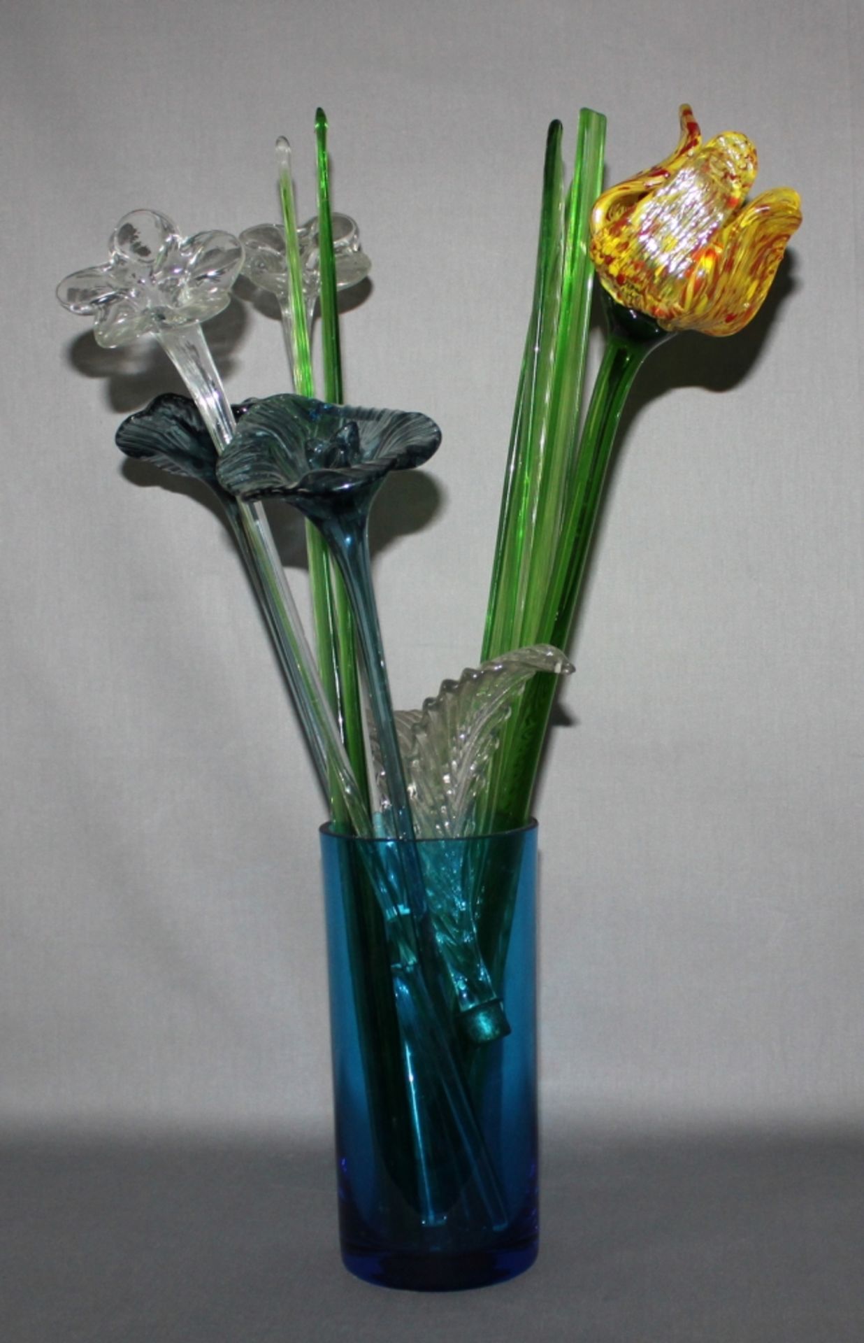 Glas. Europa. Blaue Standvase mit Glasblumenstrauß.