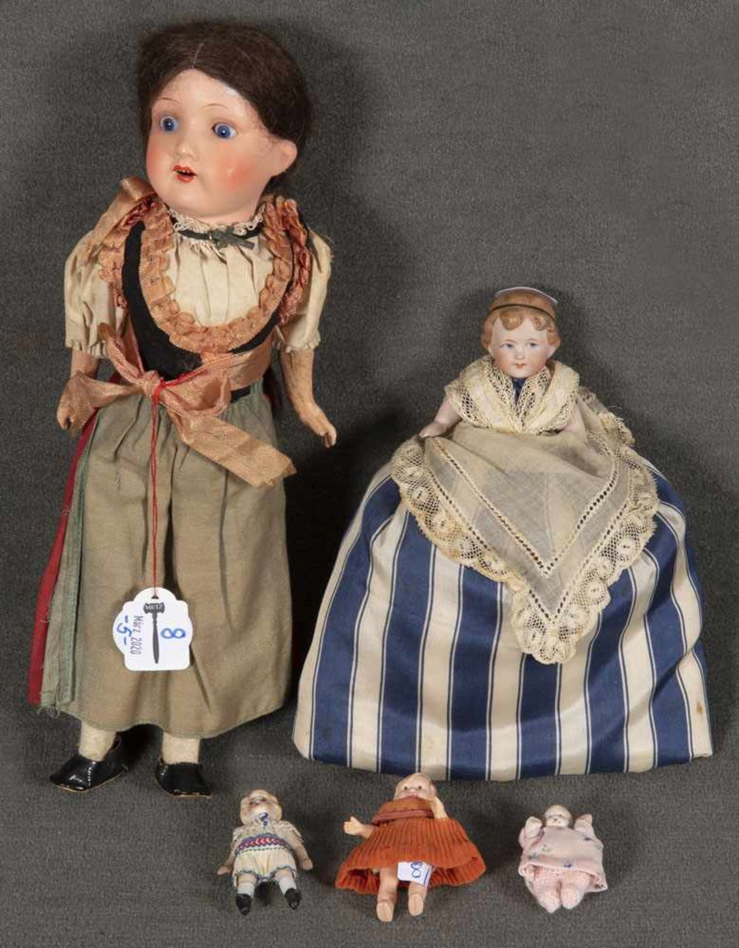 Fünf Puppen. Deutsch 20. Jh. Bestehend aus: Porzellankopfpuppe mit Schlafaugen und offenem Mund