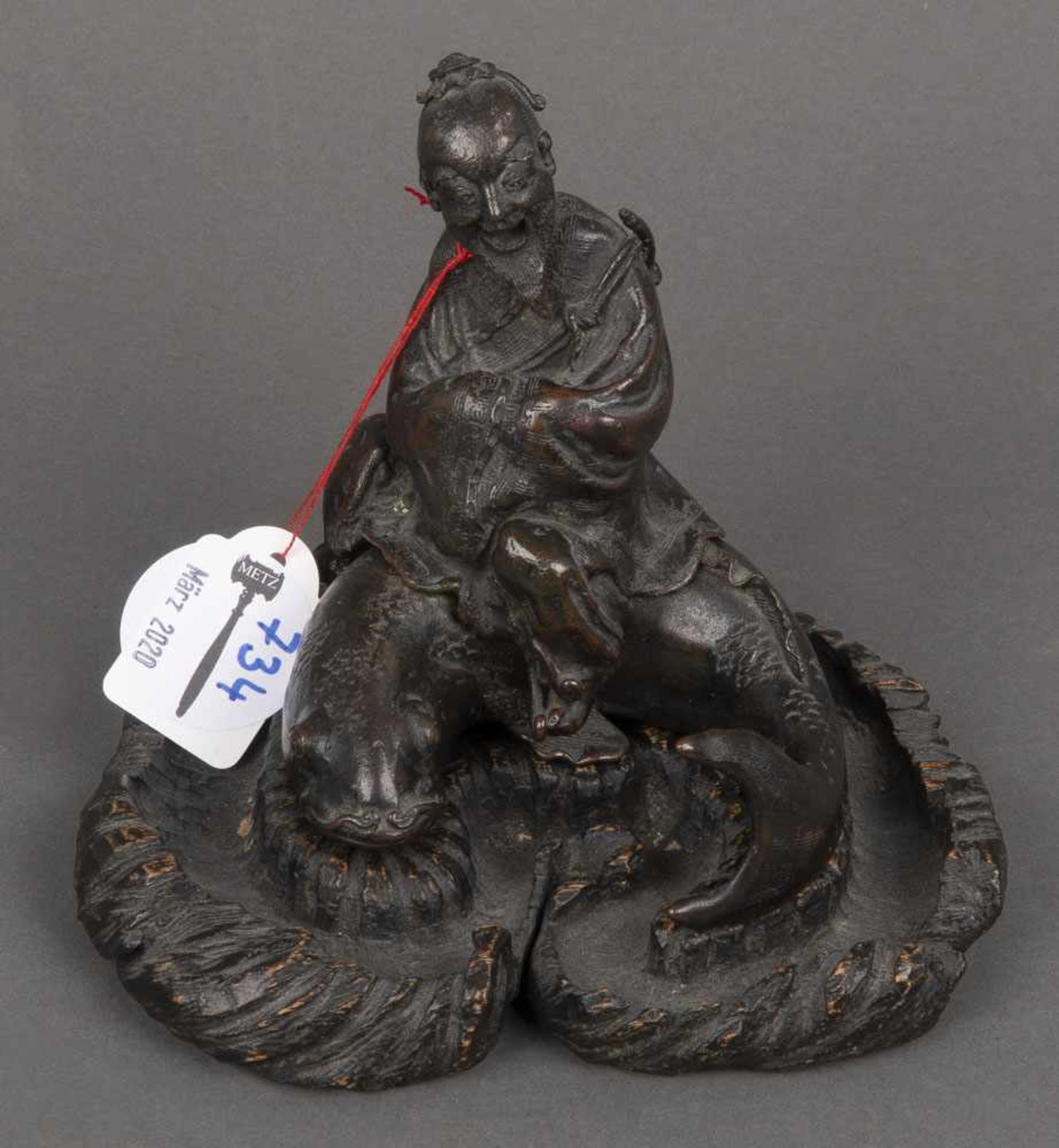 Alter Mann auf Koi. China. Bronze, brüniert, auf geschnitztem Holzsockel, H=12,8 cm.