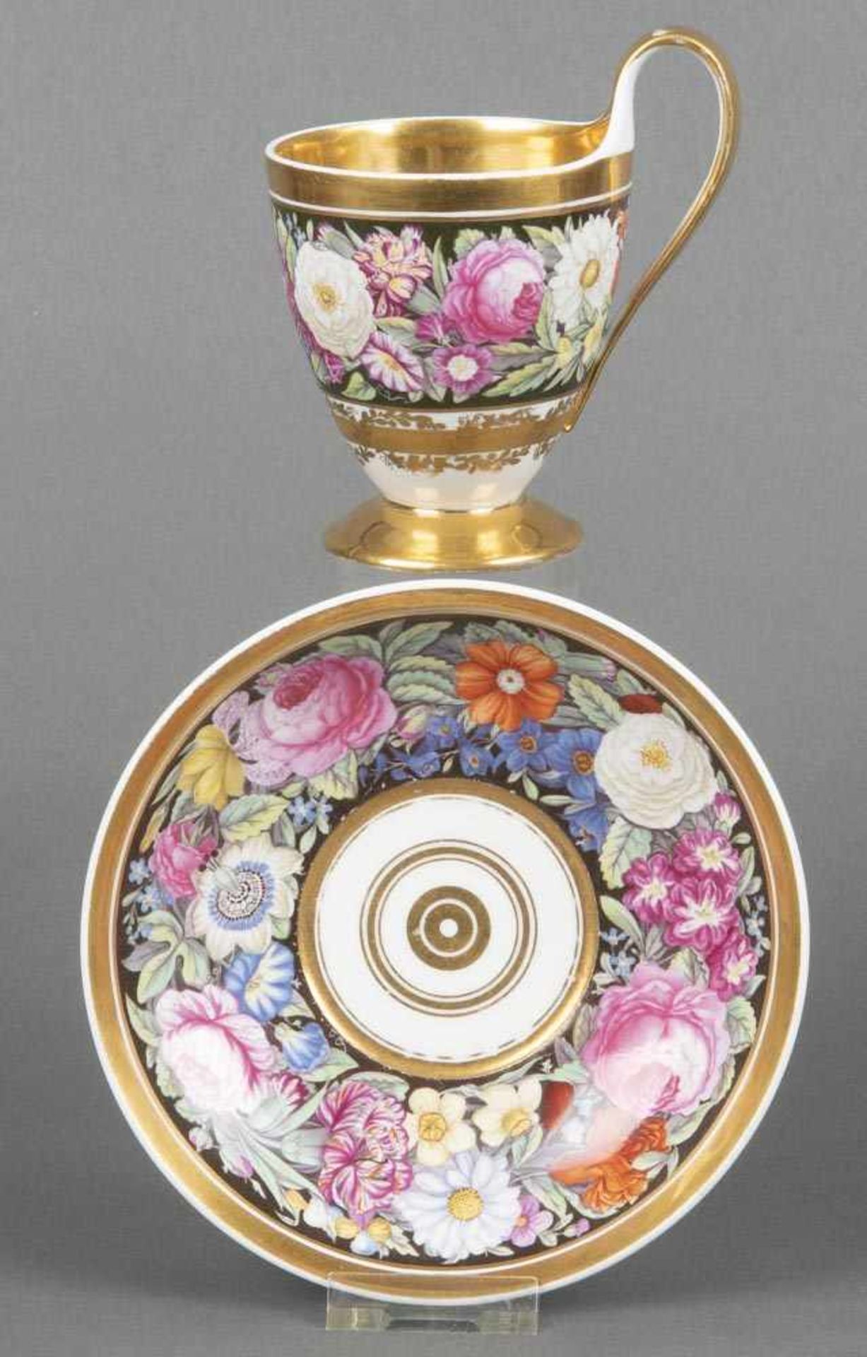 Empire-Tasse mit Unterschale. Fürstenberg um 1825. Beide Teile prächtig bunt bemalt mit Floraldekor,