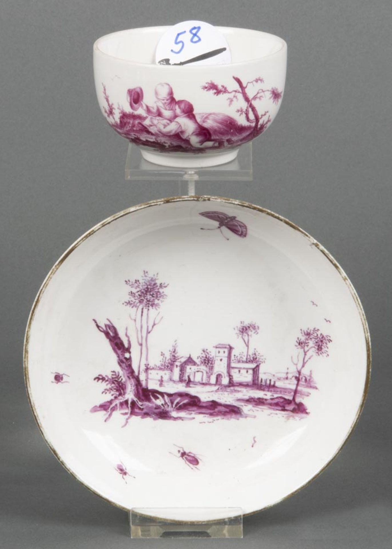 Tasse mit Unterschale. Höchst 1765. Schauseiten purpur bemalt mit Architekturlandschaft, umgeben von