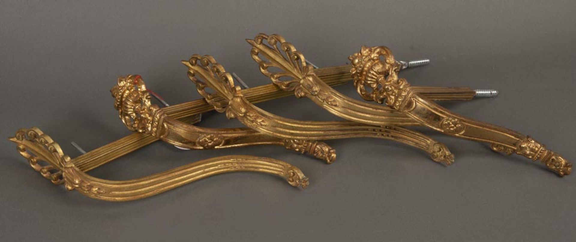 Fünf Vorhängehalterungen. Frankreich um 1900. Bronze, vergoldet, H=24 bis 29 cm, T=15 bis 18 cm.Fünf