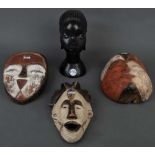 Frauenbüste und drei Kultmasken. Afrika. Holz geschnitzt, teilw. bunt gefasst, H=27 bzw. 25 cm.