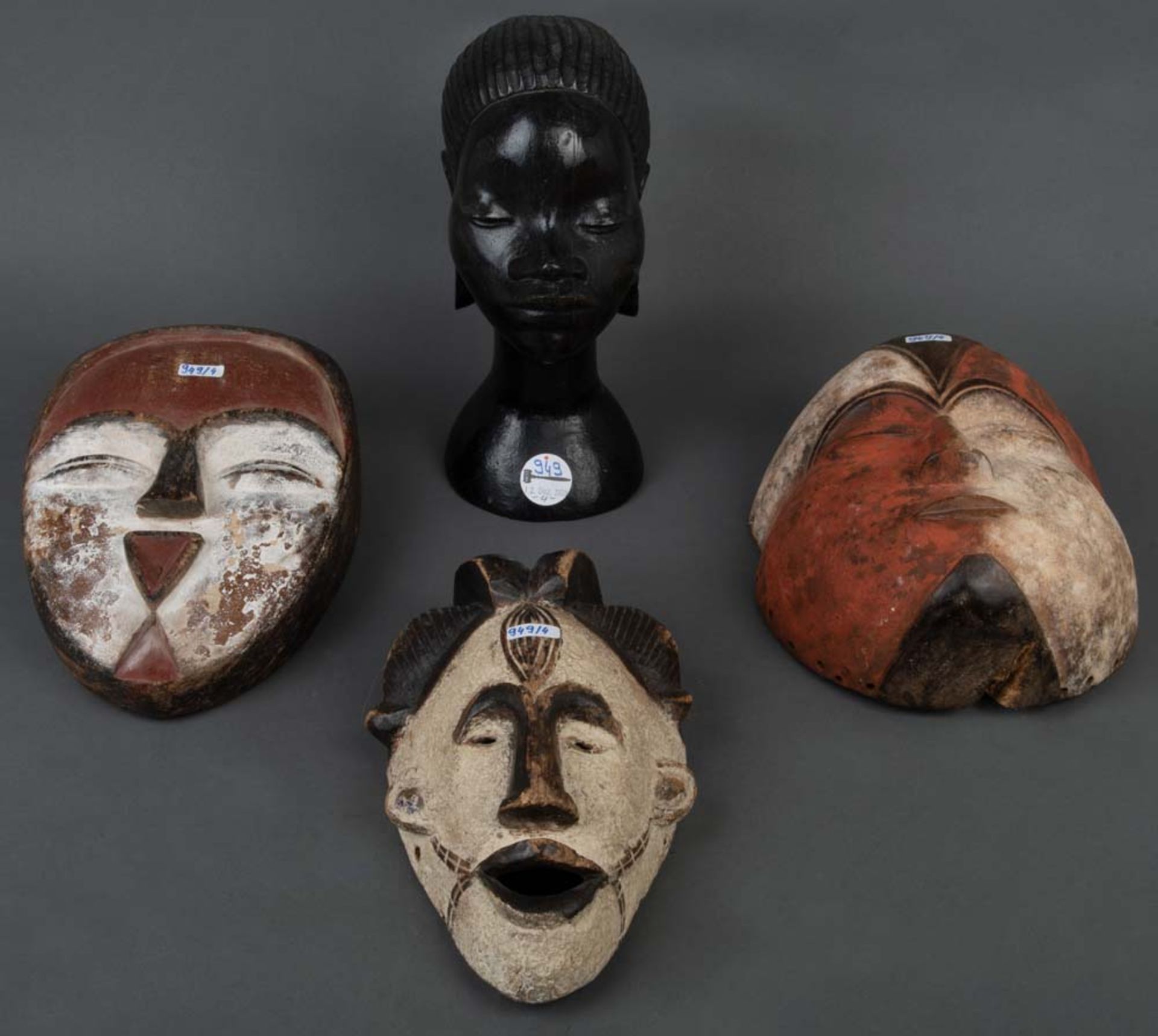 Frauenbüste und drei Kultmasken. Afrika. Holz geschnitzt, teilw. bunt gefasst, H=27 bzw. 25 cm.