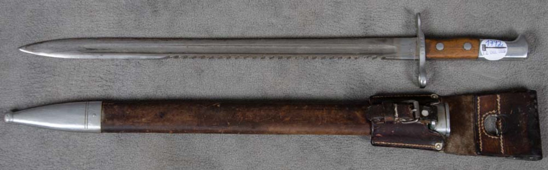 Bajonett. Schweiz 1914. Mit Sägerücken in Original-Lederscheide mit Koppelschuh, L=63 cm.