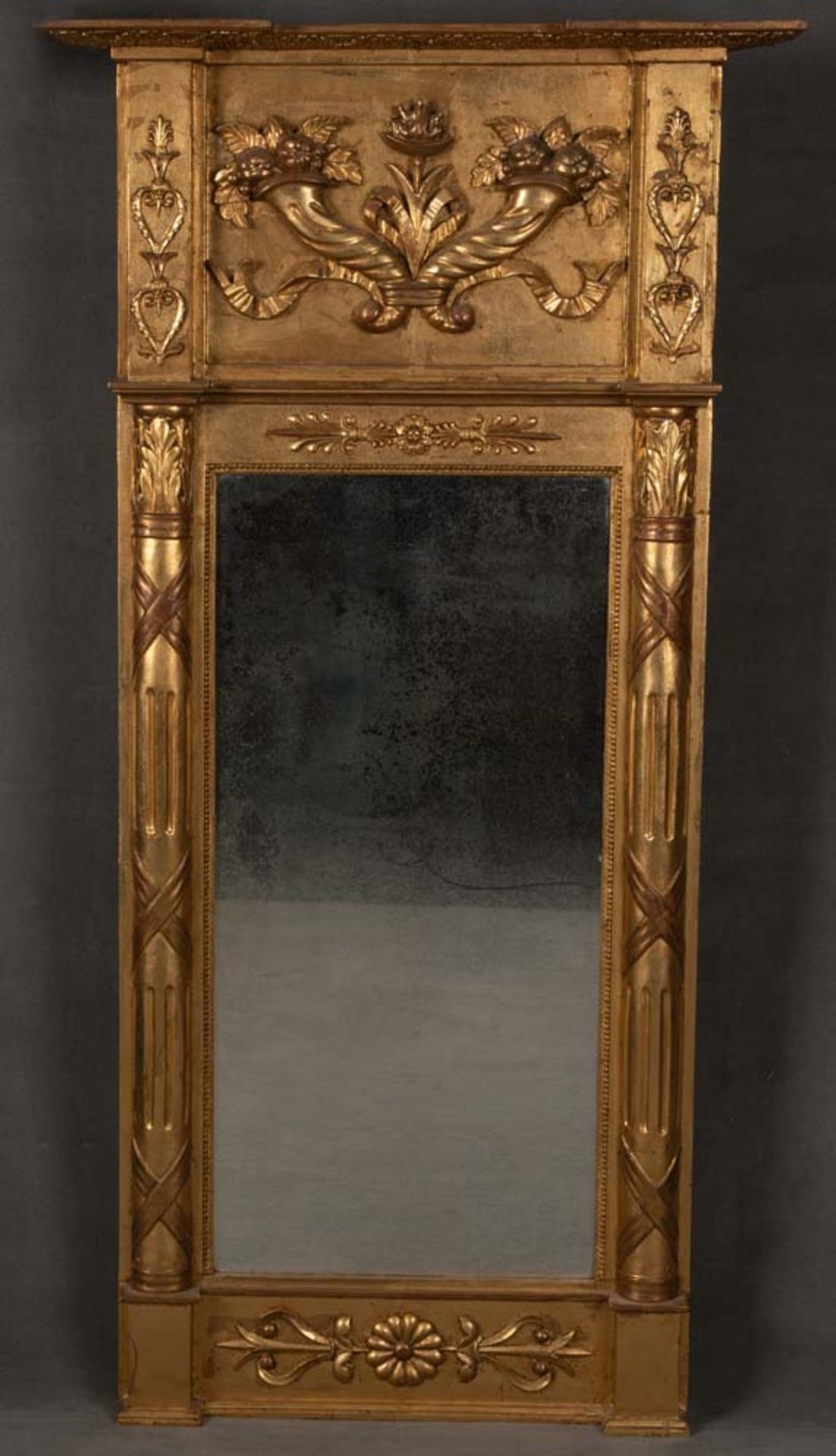Spiegel. Deutsch 19. Jh. Massivholz, teilw. geschnitzt, auf Kreidegrund gold gefasst, 140 x 73 cm.