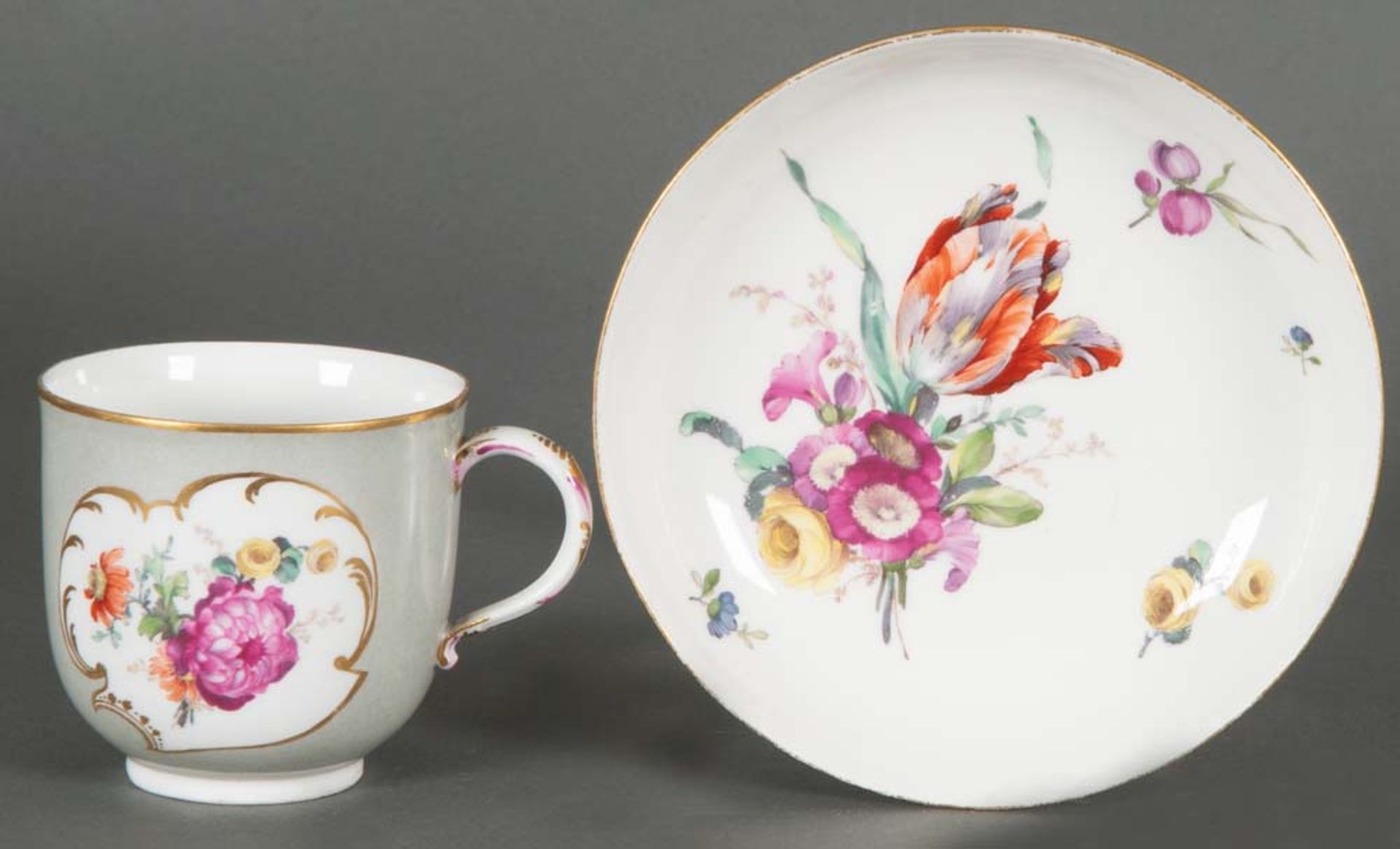 Bechertasse mit Unterschale. Berlin 1763-1770. Porzellan, mit grauem Fond, bunt bemalt mit Floraldek