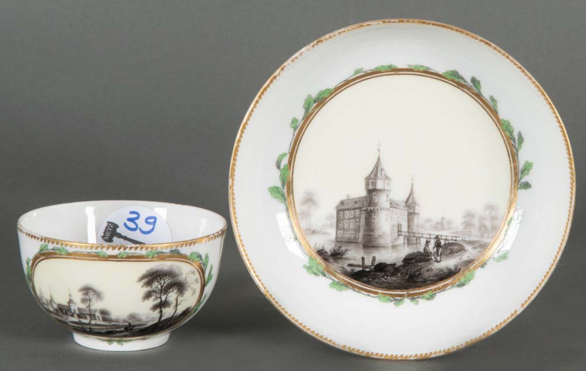 Tasse mit Unterschale. Berlin 1775. Porzellan, graucamaieu bemalt mit Architekturlandschaften, grün