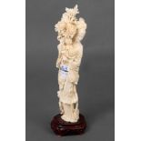 Stehende Frau mit Blumengesteck. Asien. Bein, geschnitzt, auf Holzsockel, H=30 cm.
