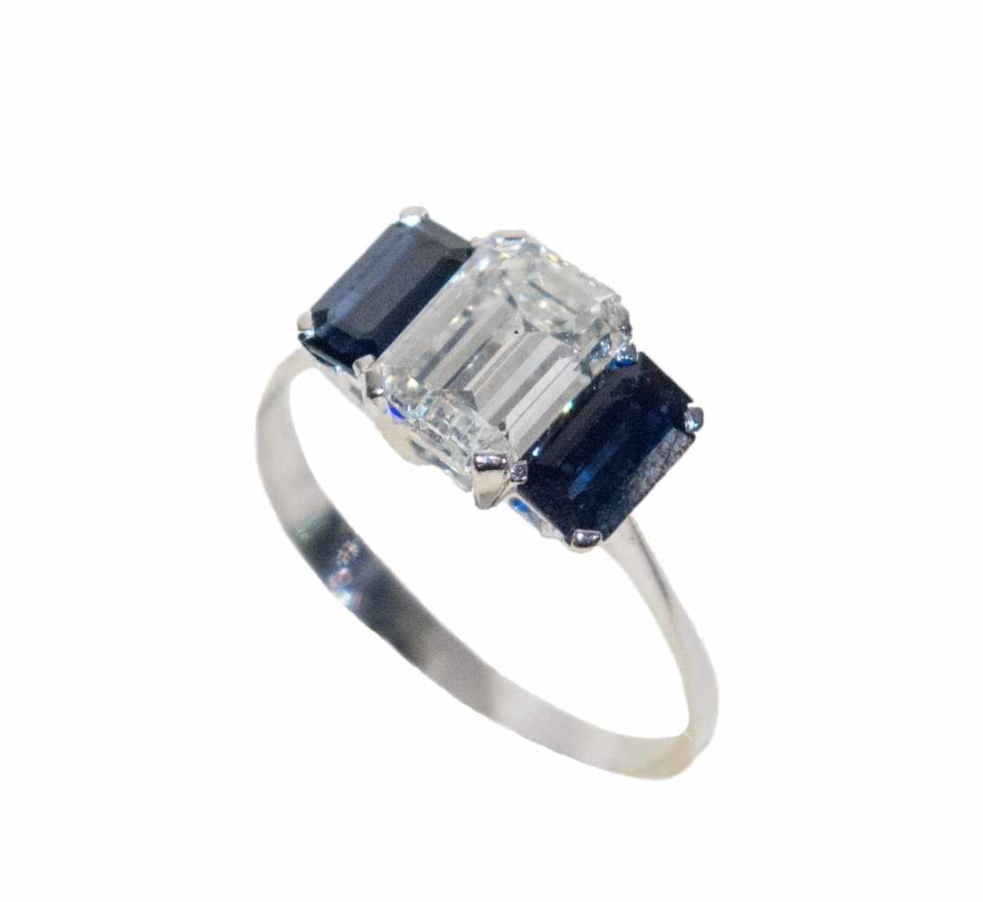 ANELLO IN ORO BIANCO 18K Realizzato con diamante tagliato a smeraldo affiancato da due zaffiri blu