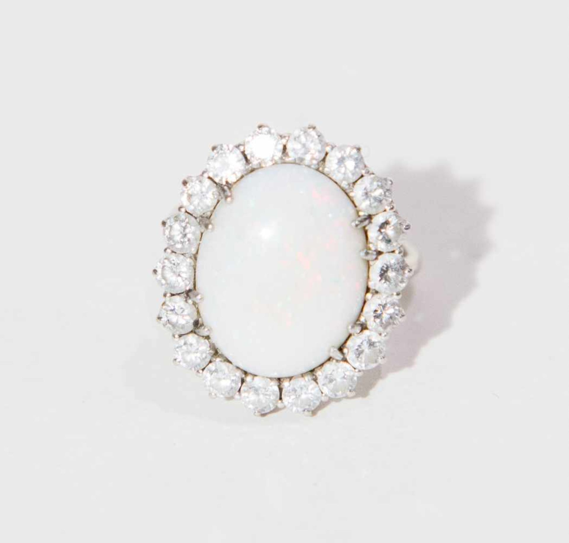 ANELLO IN ORO BIANCO 18K Decorato con cabochon ovale di opale nobile bianca posto entro cornice di