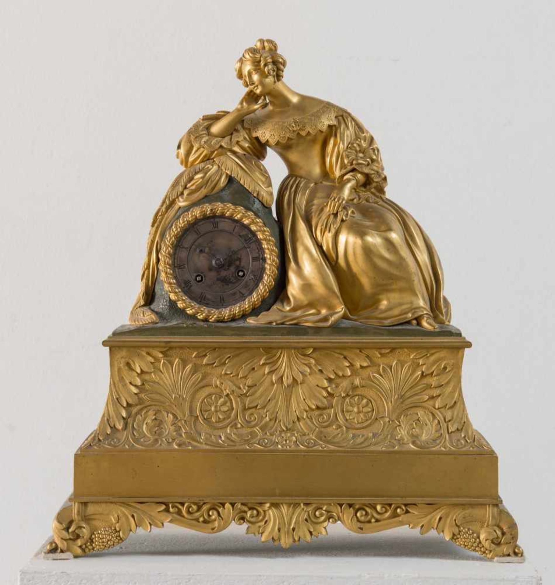 OROLOGIO IN BRONZO DORATO, Francia, prima metà del XIX secolo. Figura femminile appoggiata ad una