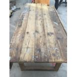 A LARGE WOODEN WORK BENCH/TABLE 244CM X 88CM (CORNER MISSING)