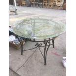 A CIRCULAR GLASS TOPPED GARDEN TABLE