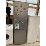 A SILVER WHIRLPOOL FRIDGE FREEZER IN NEED OF CLEAN IN WORKING ORDER