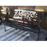 A WOODEN BENCH WITH CAST IRON ENDS AND A CAST IRON ROSE DESIGN BACK