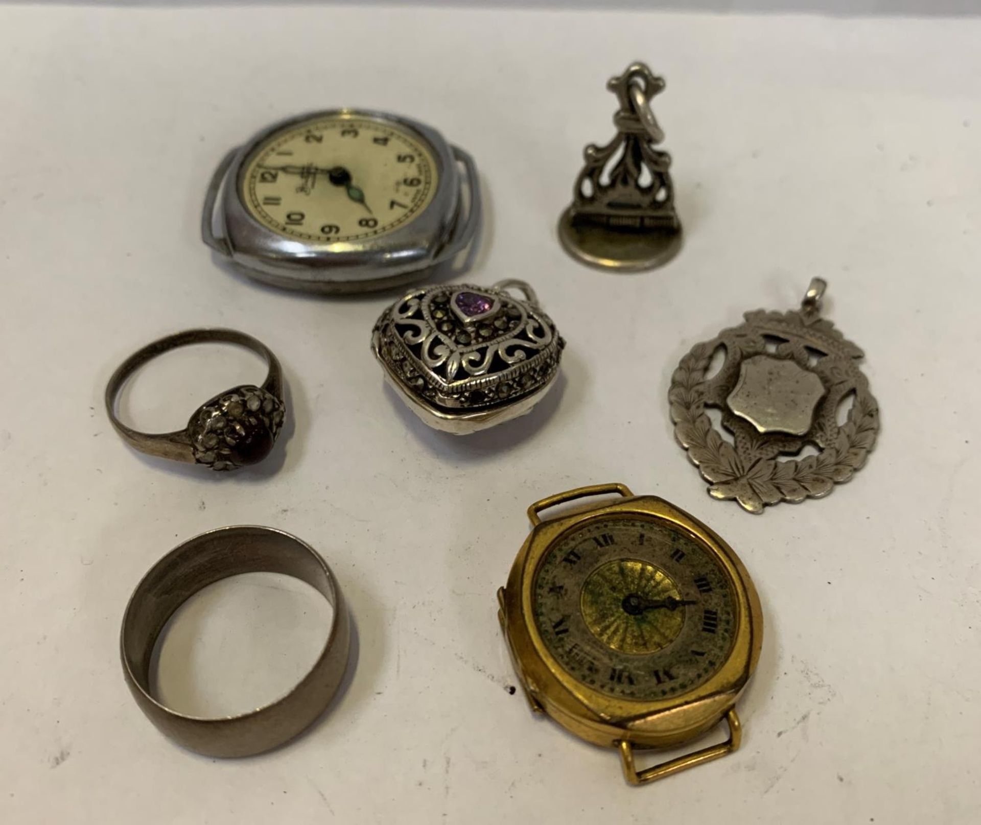 A MIXED COLLECTION OF ITEMS- TWO SILVER RINGS, A LOCKET, TWO FOBS AND TWO WATCH FACES