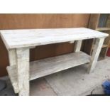 A WHITE COLOUR WASHED WOODEN TABLE WITH LOWER SHELF