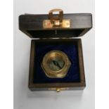 A WOODEN CASED BRASS COMPASS