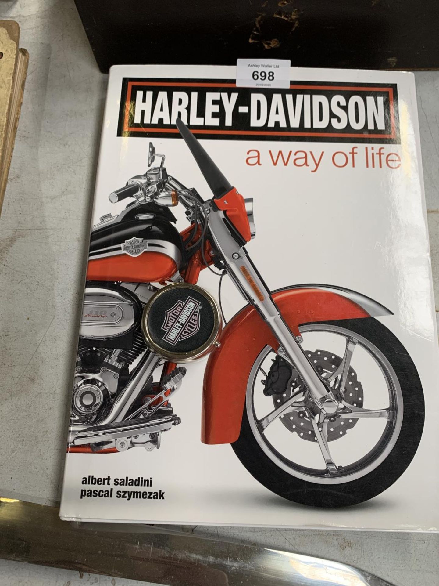 A COLLECTION OF HARLEY DAVISON MOTOR BIKE ITEMS TO INCLUDE- BOOK, LICENSE TAG FRAME AND BADGE - Image 2 of 2