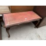 A MAHOGANY COFFEE TABLE WITH RED LEATHER TOP