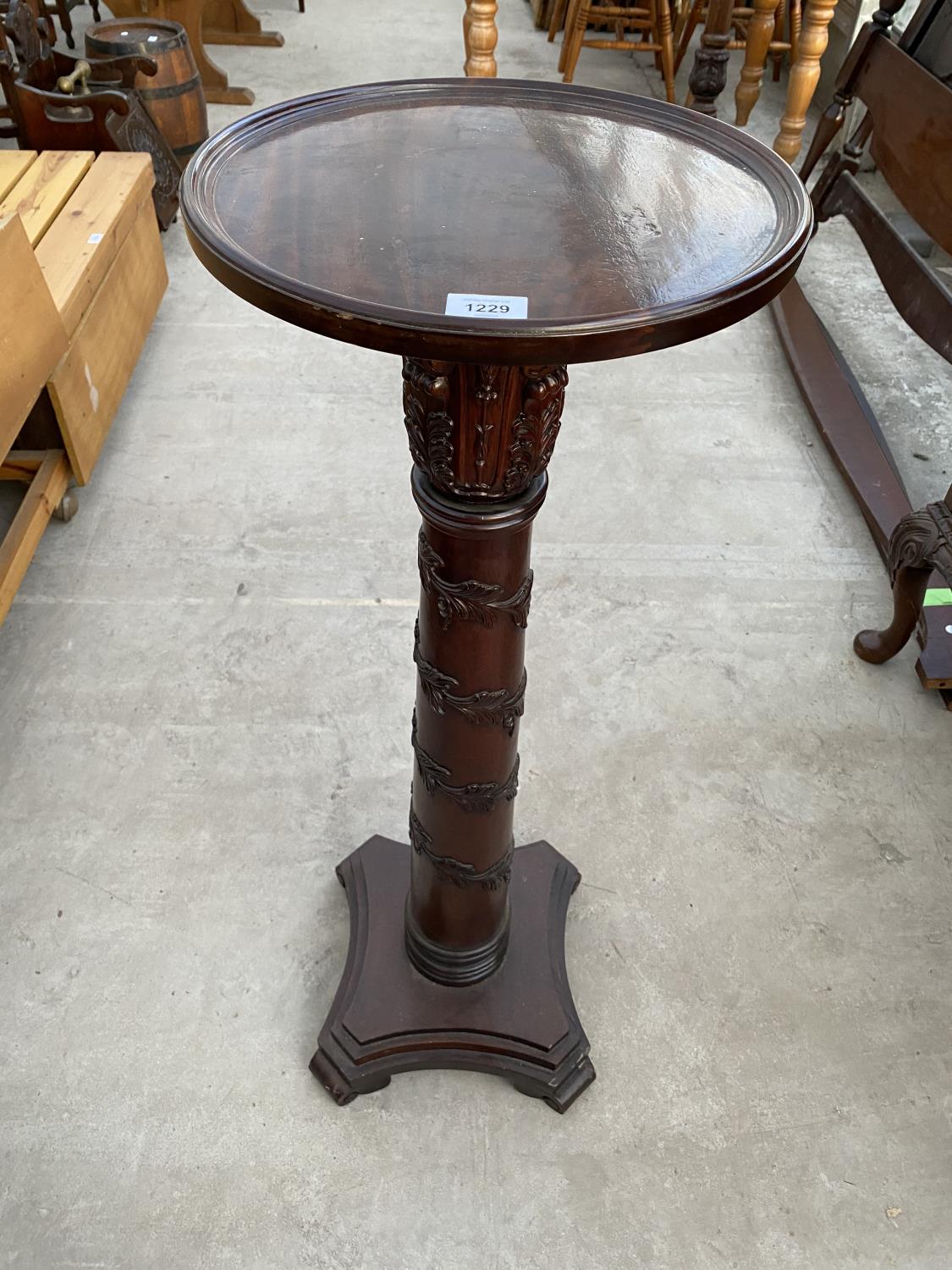 A MAHOGANY TORCHERE ON CENTRE ACANTHUS LEAF DECORATED COLUMN AND PEDESTAL BASE