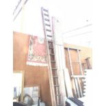 A THIRTY TWO RUNG WOODEN TWO SECTION LADDER