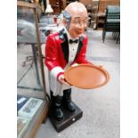 A LARGE RESIN MODEL OF A WAITER HOLDING A TRAY