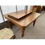 A MAHOGANY WIND OUT DINING TABLE WITH TWO EXTRA LEAVES AND WINDING HANDLE