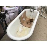 A CAST IRON BATH WITH CLAW FEET AND CHROME TAPS