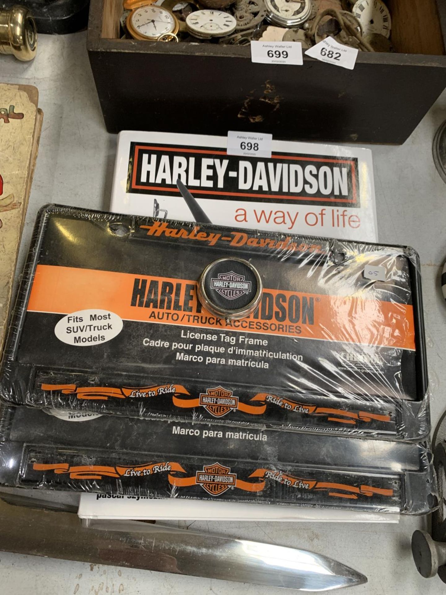A COLLECTION OF HARLEY DAVISON MOTOR BIKE ITEMS TO INCLUDE- BOOK, LICENSE TAG FRAME AND BADGE